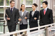 Photo: Four Business Colleagues Having Discussion Whilst Walking Outsid Four Business Colleagues Having Discussion Whilst Walking Outsid