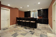 Bar in basement with dark wood cabinetry