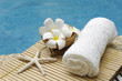 Spa setting on bamboo mat near swimming pool