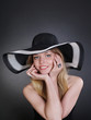 Foto: Portrait of the beautiful young woman in a fashionable black hat Portrait of the beautiful young woman in a fashionable black hat