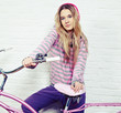 Foto: young woman with pink bike at home young woman with pink bike at home