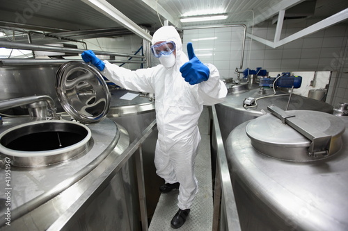 Photo: technician in uniform, in lab with thumb up gesture technician in uniform, in lab with thumb up gesture