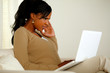 Young woman with headache working on laptop