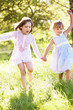 Photo: Two Young Girls Walking Through Summer Field Together Two Young Girls Walking Through Summer Field Together