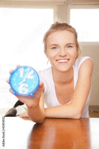 Photo: happy and smiling teenage girl with clock happy and smiling teenage girl with clock