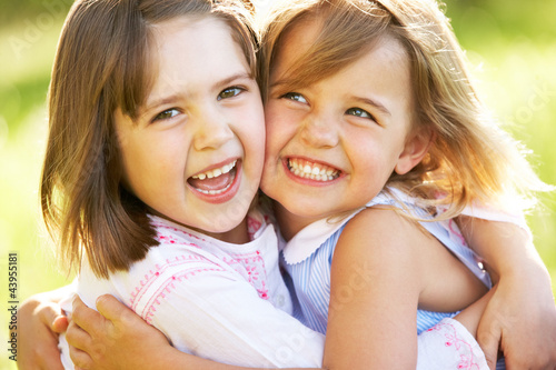 Photo: Two Young Girls Giving One Another Hug In Summer Field Two Young Girls Giving One Another Hug In Summer Field