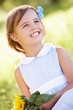 Young Girl Sitting In Summer Field Holding Sunflower