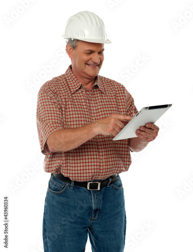 Photo: Aged architect using tablet pc Aged architect using tablet pc