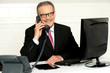 Photo: Senior businessman attending phone call Senior businessman attending phone call