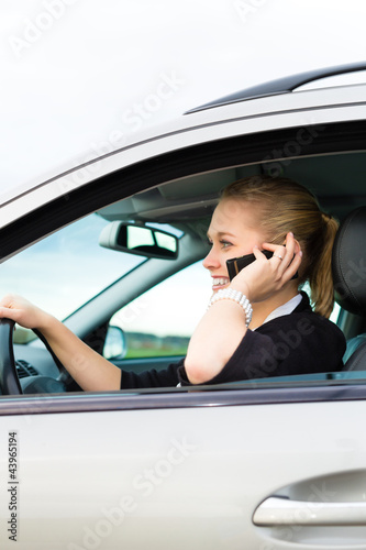 Photo: Junge Frau mit Telefon im Auto Junge Frau mit Telefon im Auto