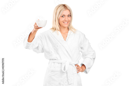 Photo: A blond woman in bathrobe holding a coffee cup A blond woman in bathrobe holding a coffee cup