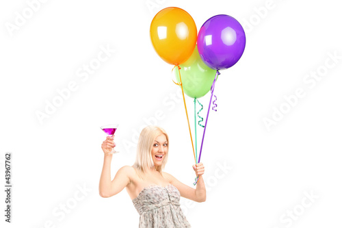 Foto: An attractive woman holding balloons and cocktail An attractive woman holding balloons and cocktail