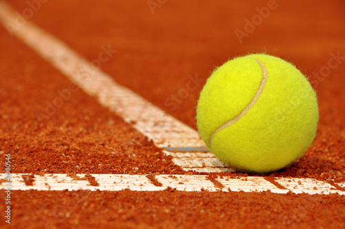 Photo: Tennis ball on a tennis clay court Tennis ball on a tennis clay court