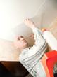 Man glues ceiling tile