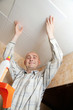 guy glues ceiling tile
