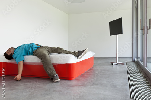 Photo: interior modern hotel room, guy lying on the bed interior modern hotel room, guy lying on the bed