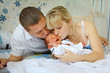 Photo: Happy mother and father kissing little newborn Happy mother and father kissing little newborn