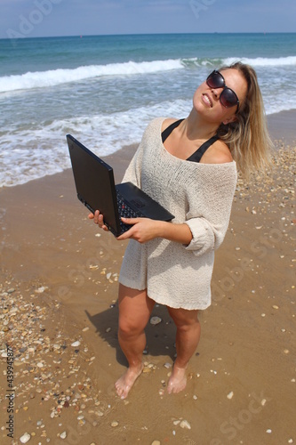 Photo: Beautiful blonde at the beach with laptop Beautiful blonde at the beach with laptop