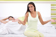 disappointed woman sitting on the bed next to her husband