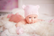 newborn baby girl in pink knitted bear hat
