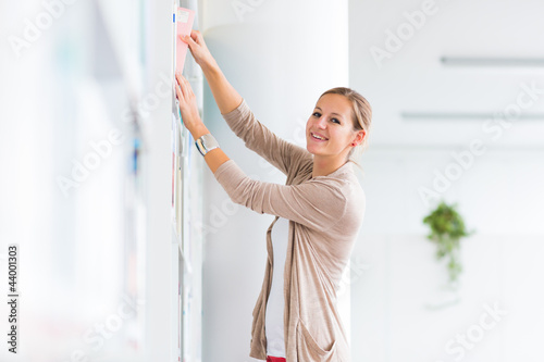 Photo: pretty young college student in a library (shallow DOF; color to pretty young college student in a library (shallow DOF; color to