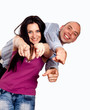 Portrait of happy young couple pointing at you over white backgr