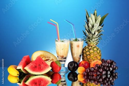 Photo: Milk shakes with fruit on blue background close-up Milk shakes with fruit on blue background close-up