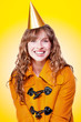 Laughing winter party girl on yellow background