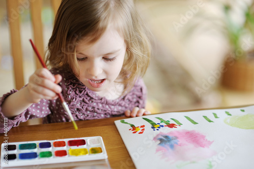 Photo: Cute little girl is drawing with paints Cute little girl is drawing with paints