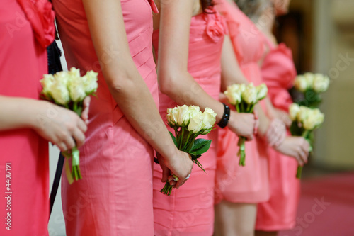 Photo: Row of bridesmaids with bouquets at wedding Row of bridesmaids with bouquets at wedding