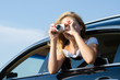 Photographer leaning out of car window
