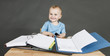 baby with paperwork at wooden desk