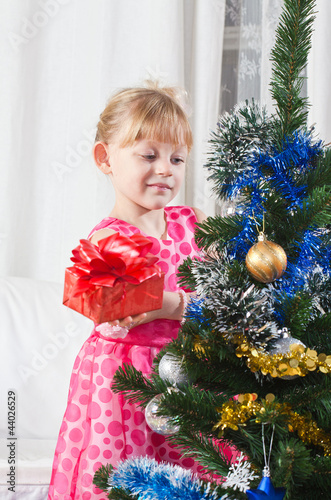 Photo: girl with gifts near a New Year tree girl with gifts near a New Year tree