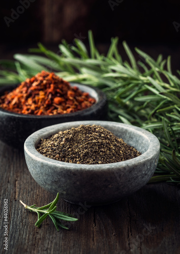 Photo: Black pepper in bowl; chili flakes and rosemary in background Black pepper in bowl; chili flakes and rosemary in background