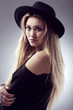 Beautiful blonde in black with hat on her had