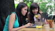 Two female friends with modern laptop in bar, steadicam shot