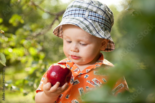 Photo: Little boy in panama with red apple Little boy in panama with red apple