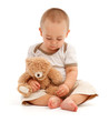 Little boy playing with toy bear