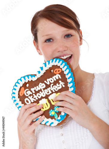 Foto: Attraktive Frau beißt in Lebkuchen Herz vom Oktoberfest Attraktive Frau beißt in Lebkuchen Herz vom Oktoberfest