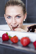junge Frau isst Schokolade und Erdbeeren