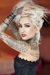 Portrait of tattooed young woman wearing corset with hands in hair