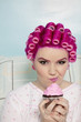 Portrait of a young woman making face while holding cupcake