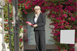 Photo: Portrait of a cheerful senior real estate agent with clipboard Portrait of a cheerful senior real estate agent with clipboard