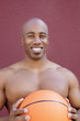 Photo: Portrait of a shirtless African American man with basketball over colored background Portrait of a shirtless African American man with basketball over colored background