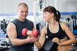 The woman with the trainer in sports club