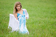 The beautiful woman in a blue dress in the field
