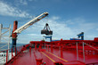 coal is being loaded onto tankers with a crane