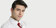 Photo: Close-up portrait of a handsome Indian male doctor smiling over light gray background Close-up portrait of a handsome Indian male doctor smiling over light gray background
