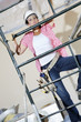 Front view of female worker climbing on scaffold