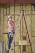 Female contractor climbing up the ladder at construction site
